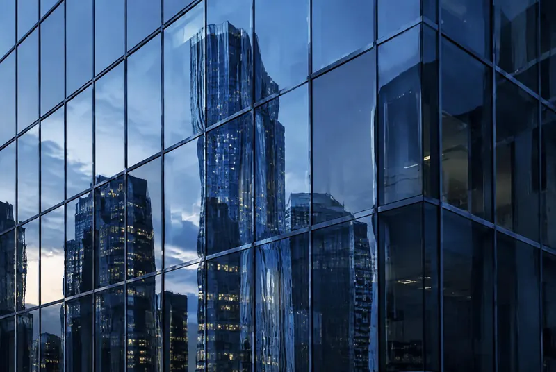 Abstract reflections of towers in a glass façade at blue hour